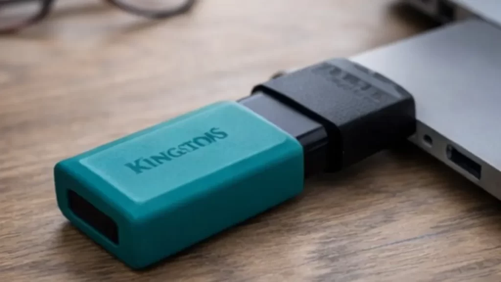 Pendrive SanDisk Cruzer Blade USB 2.0 preto e vermelho apoiado sobre superfície clara, modelo compacto e portátil