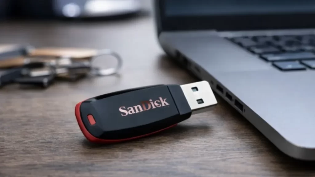 Pendrive SanDisk Cruzer Blade USB 2.0 preto e vermelho apoiado sobre superfície clara, modelo compacto e portátil