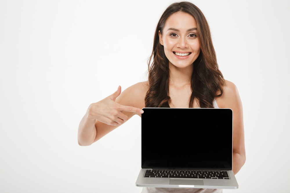 Mulher apontando para a tela de um notebook, ilustrando a escolha do tamanho e tipo de tela para conforto visual e mobilidade.