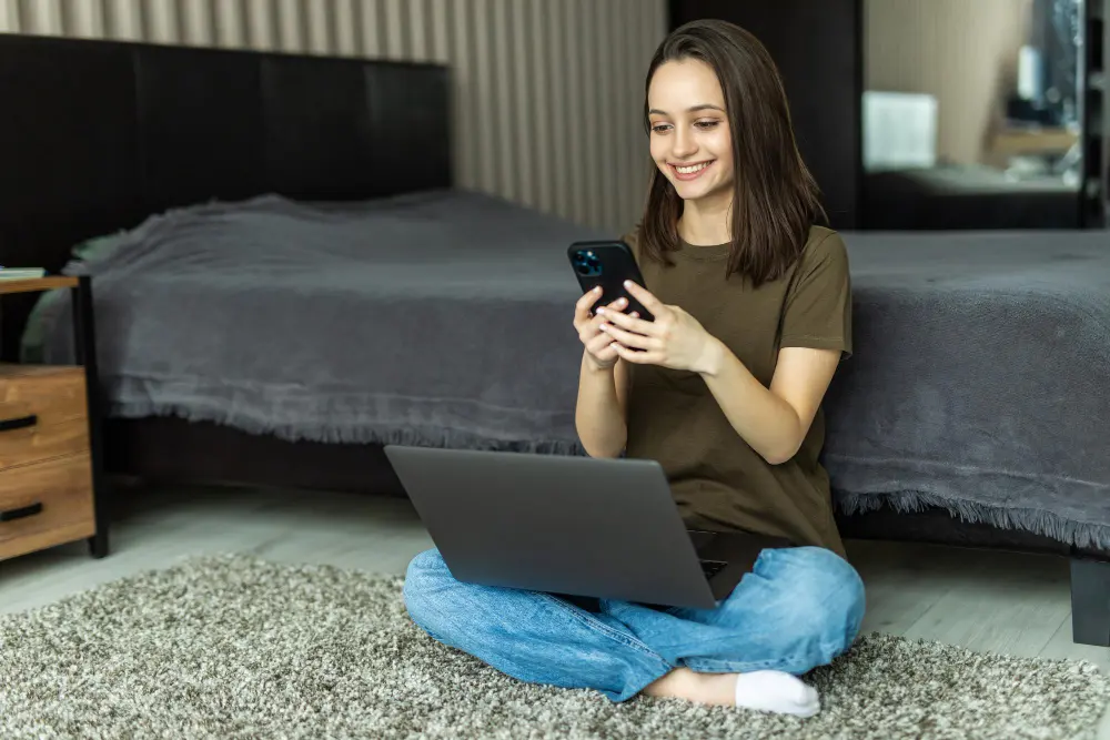 Mulher usando WiFi hotspot do celular para compartilhar internet com notebook
